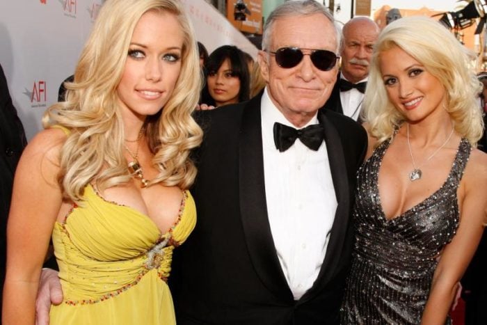 Kendra Wilkinson and Holly in a yellow dress next to Hugh Hefner