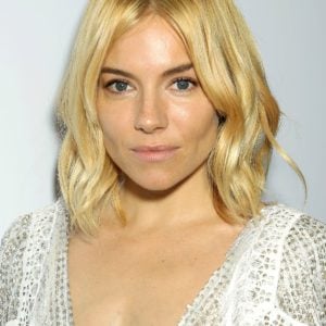 Sienna Miller in a low cut white dress exposing cleavage